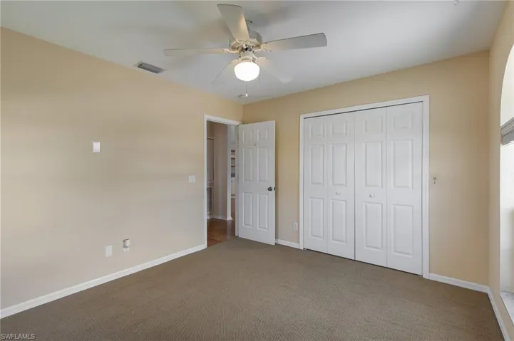 Unfurnished bedroom featuring carpet, a ceiling fan, and a closet