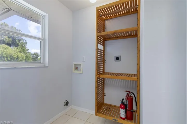 Laundry area with light tile patterned floors, hookup for an electric dryer, and hookup for a washing machine