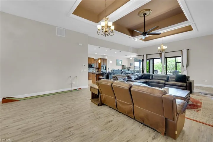 Wide open great room featuring spectacular waterfront views, high tray ceilings, nicely finished light fixtures, tile throughout and ceiling fan.