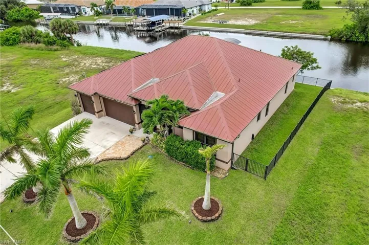 Aerial view of right side of home, metal roof and with views of the waterfront