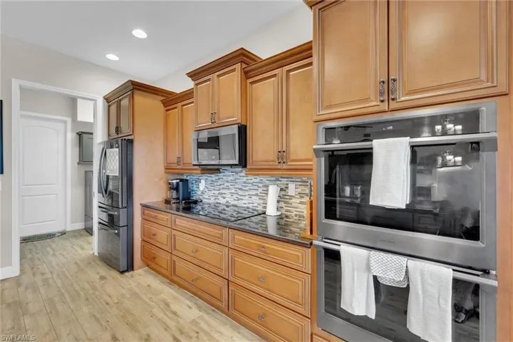 Fully upgraded Kitchen featuring recessed lighting, stainless steel appliances, a DOUBLE OVEN, seamless backsplash, and granite countertops.