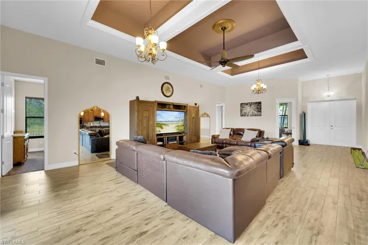 Wide open great room featuring spectacular waterfront views, high tray ceilings, nicely finished light fixtures, tile throughout and ceiling fan.