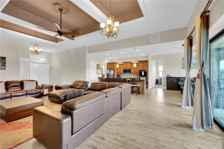 Wide open great room featuring spectacular waterfront views, high tray ceilings, nicely finished light fixtures, tile throughout and ceiling fan.