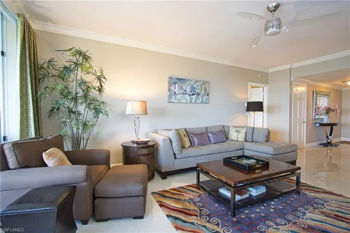 Living room featuring crown molding and ceiling fan