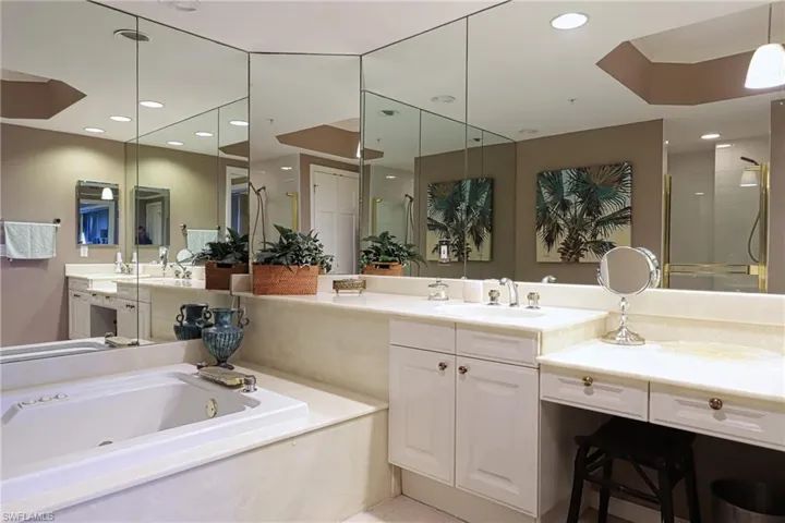Bathroom featuring vanity with extensive cabinet space and a bath