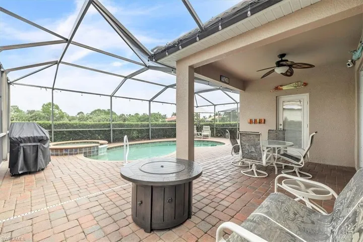 Screened pool enclosure featuring a pool and integrated spa