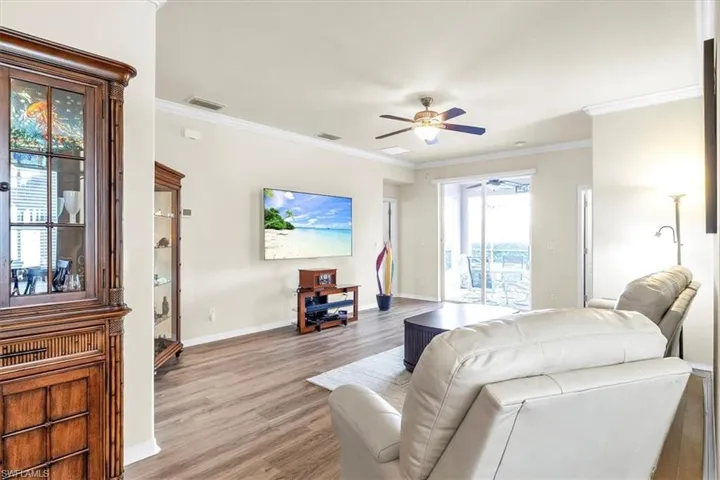 Spacious interior featuring wood-finish flooring, crown molding, and a ceiling fan