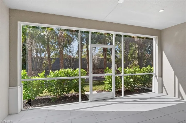 Doorway featuring tile patterned flooring, a textured wall, and healthy amount of natural light