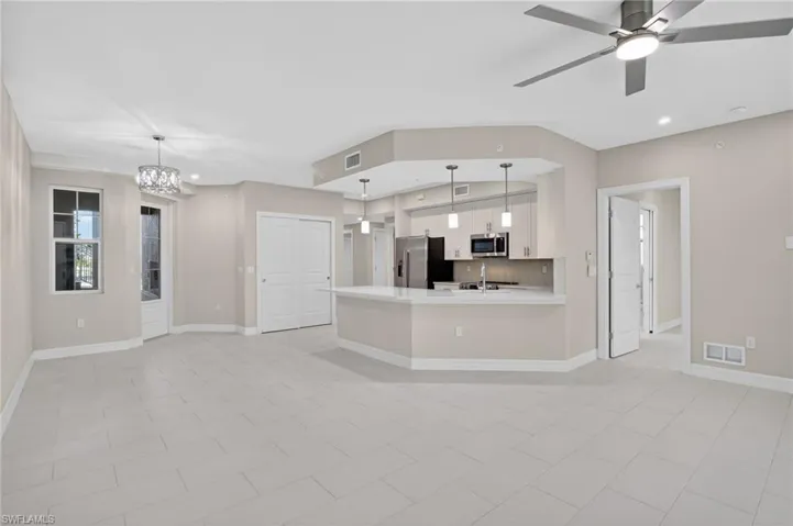 Kitchen featuring light countertops, white cabinets, a peninsula, stainless steel appliances, and ceiling fan