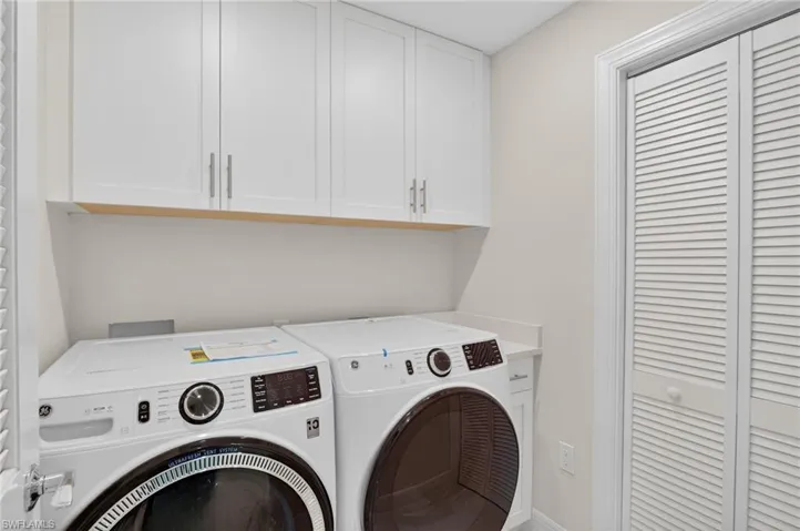 Laundry room with separate washer and dryer and cabinet space