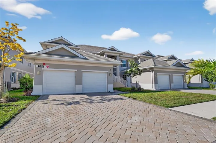 Ranch-style home featuring decorative driveway, stucco siding, a front lawn, an attached garage, and a tiled roof