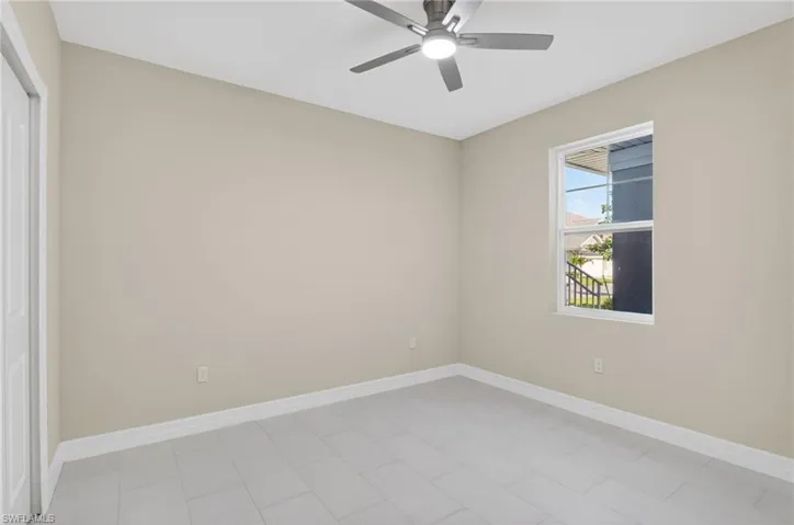 Empty room featuring baseboards and ceiling fan