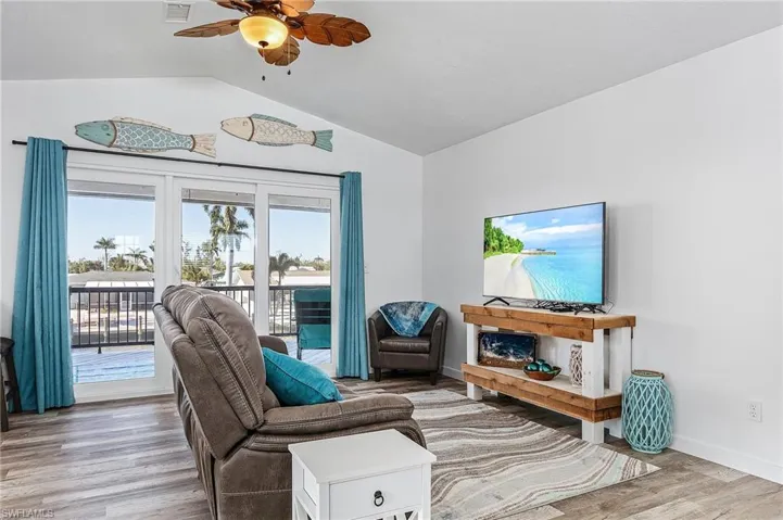 Living Room with hurricane sliders to the upper deck overlooking pool and canal.