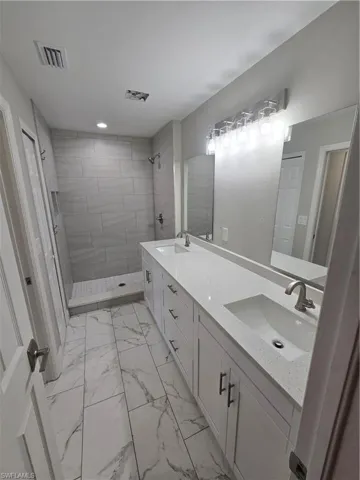 Bathroom featuring a tile shower and vanity