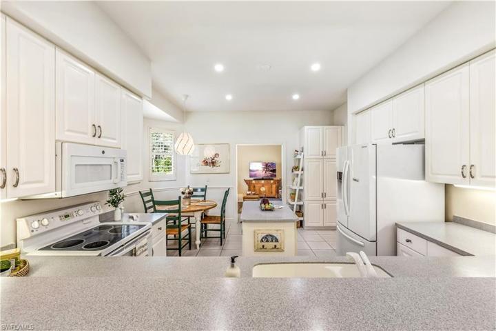 Kitchen opens to den, dining, and living area