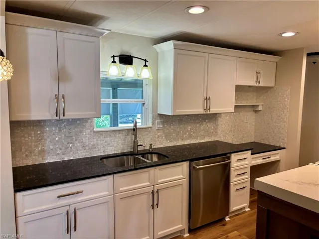 Window over kitchen sink which allows lots of natural sunlight. Granite countertops.