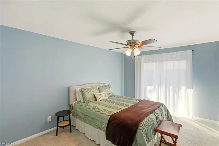 Carpeted bedroom with baseboards and a ceiling fan