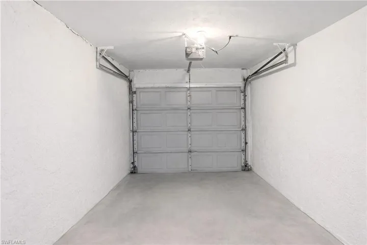 Garage with a textured wall and a garage door opener