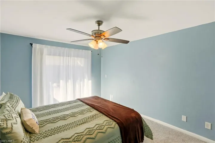Carpeted bedroom featuring baseboards and ceiling fan
