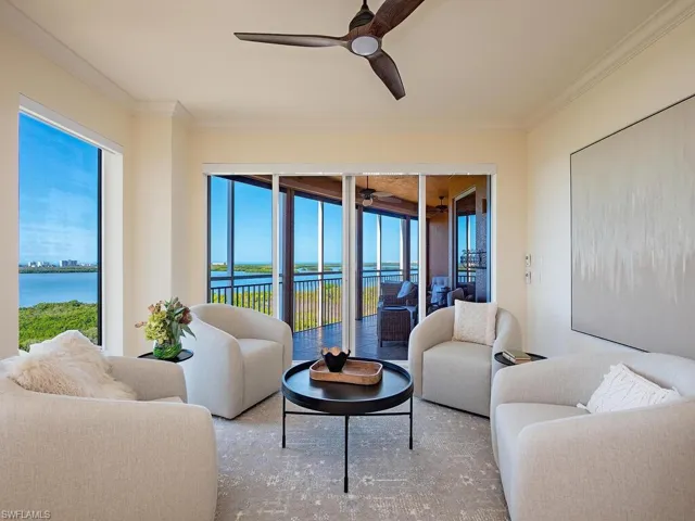 Living area featuring a water view, ornamental molding, a sunroom, and ceiling fan