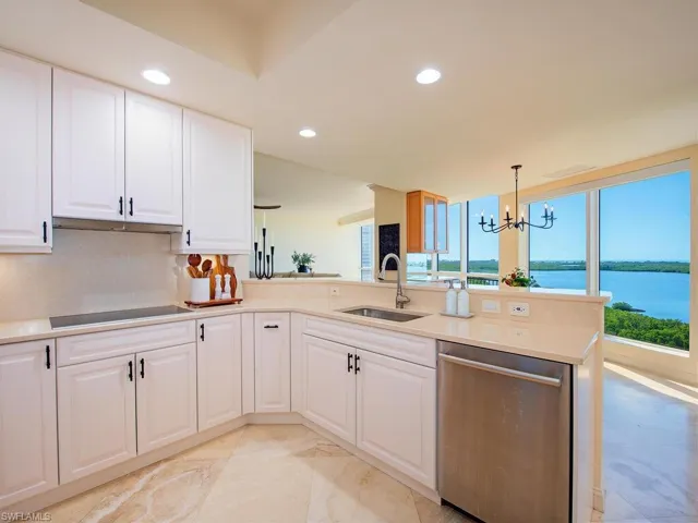 Kitchen with dishwasher, white cabinetry, a chandelier, hanging light fixtures, and recessed lighting