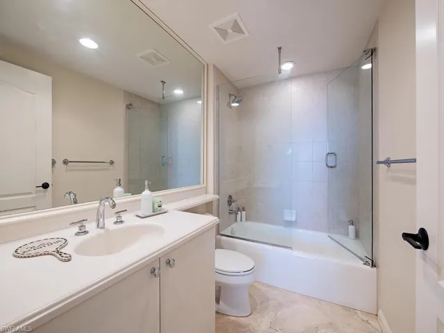 Bathroom featuring vanity, enclosed tub / shower combo, and recessed lighting