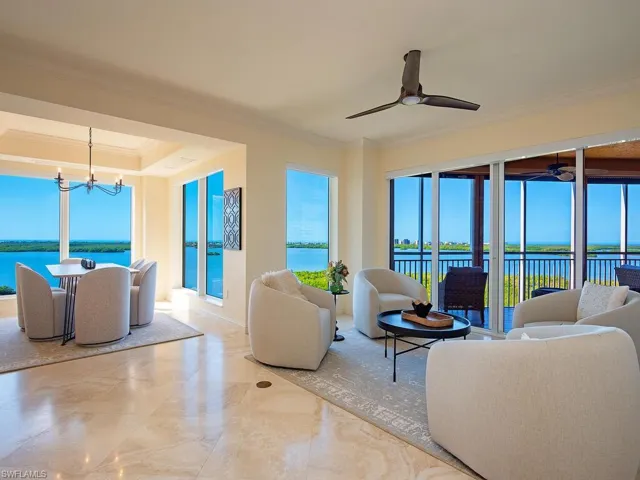 Living area featuring a water view, ornamental molding, a chandelier, and plenty of natural light