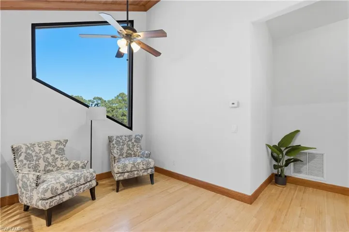 Sitting room with light wood-style flooring and a ceiling fan