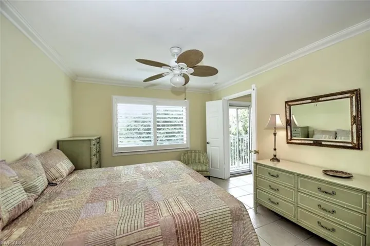 Bedroom with access to outside, ceiling fan, ornamental molding, and light tile patterned flooring