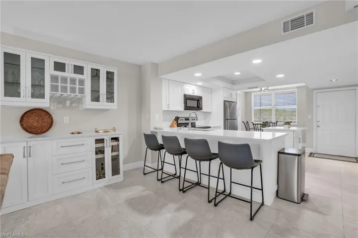 Kitchen with a breakfast bar, white cabinetry, and appliances with stainless steel finishes