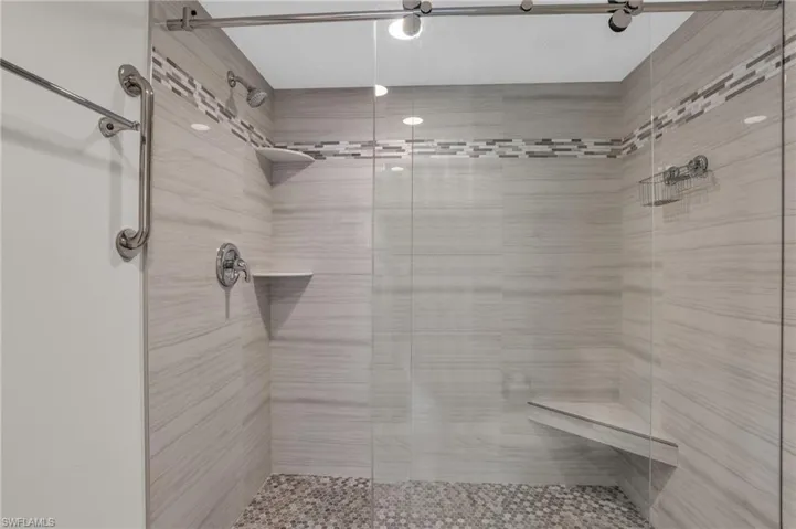 Primary bathroom featuring a renovated walk in tiled shower