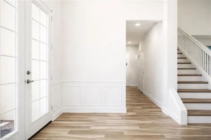 Entryway featuring light wood-style flooring, wainscoted wall, and recessed lighting