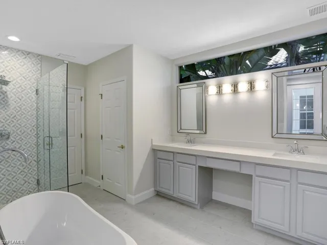 Full bathroom with a soaking tub, double vanity, and a stall shower