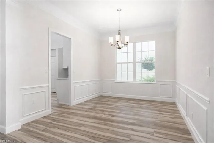 dining area with crown molding, wainscoting, and tile wood-style floors