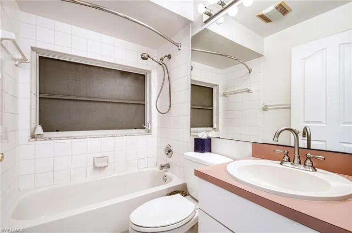 Full bathroom with vanity, toilet, and tiled shower / bath combo