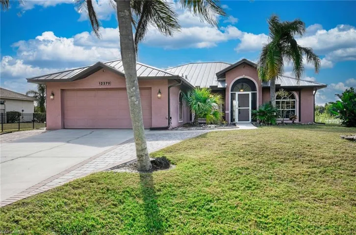 Single story home featuring a front yard and a garage