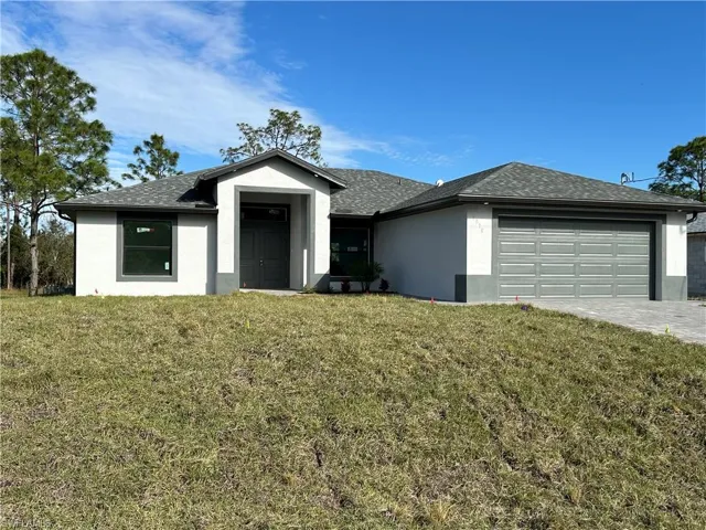View of front facade featuring a front yard and a garage