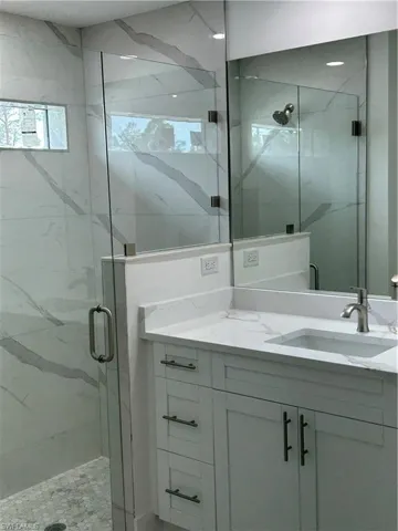 Bathroom featuring an enclosed shower and vanity