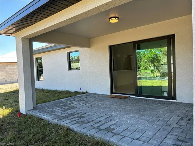 View of exterior entry with a patio