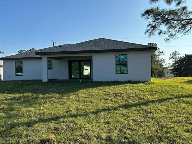 Rear view of property with a lawn