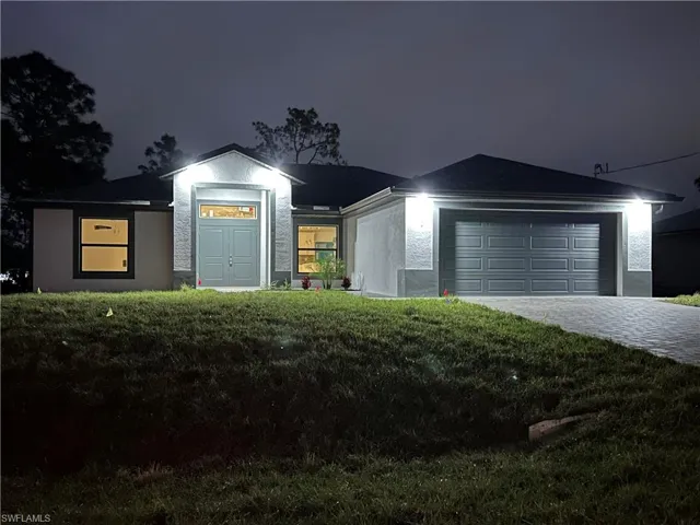 View of front of house featuring a yard and a garage