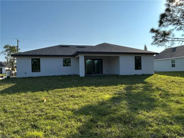 Rear view of house featuring a yard