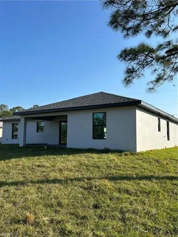 Back of house with a yard
