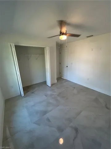 Unfurnished bedroom featuring a textured ceiling, a closet, and ceiling fan