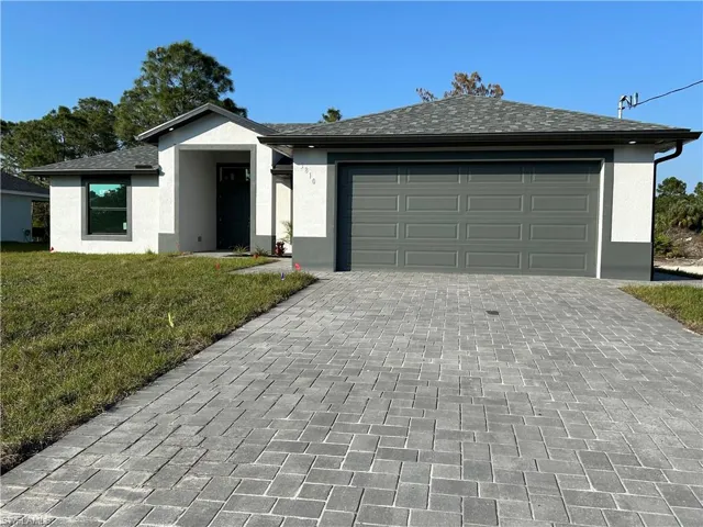 Ranch-style house with a front lawn and a garage
