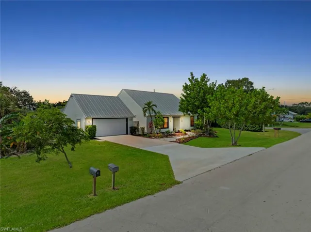 Exterior featuring a metal roof and landscaped yard