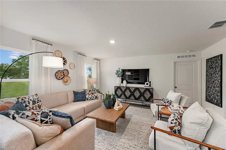 Photos are of a model home or artist rendering. Home may be virtually staged; Living room with a textured ceiling
