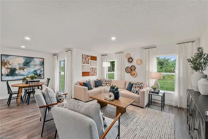 Photos are of a model home or artist rendering. Home may be virtually staged; Living room featuring a textured ceiling and hardwood / wood-style floors
