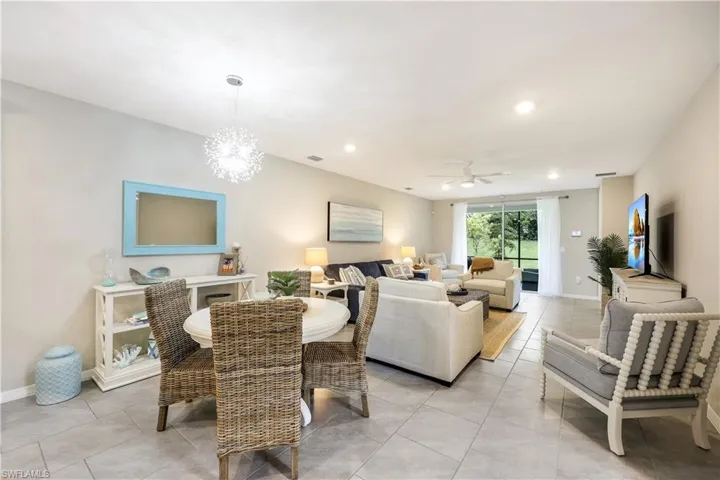 Dining space featuring light tile patterned floors, recessed lighting, ceiling fan, and a chandelier