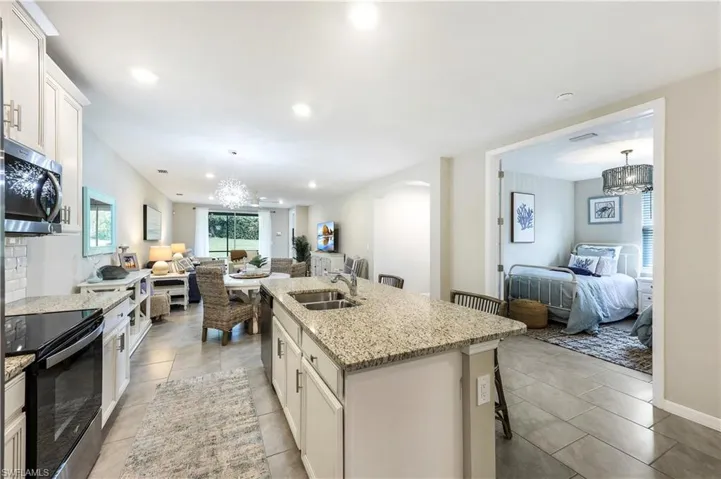 Kitchen with open floor plan, white cabinetry, a chandelier, appliances with stainless steel finishes, and recessed lighting